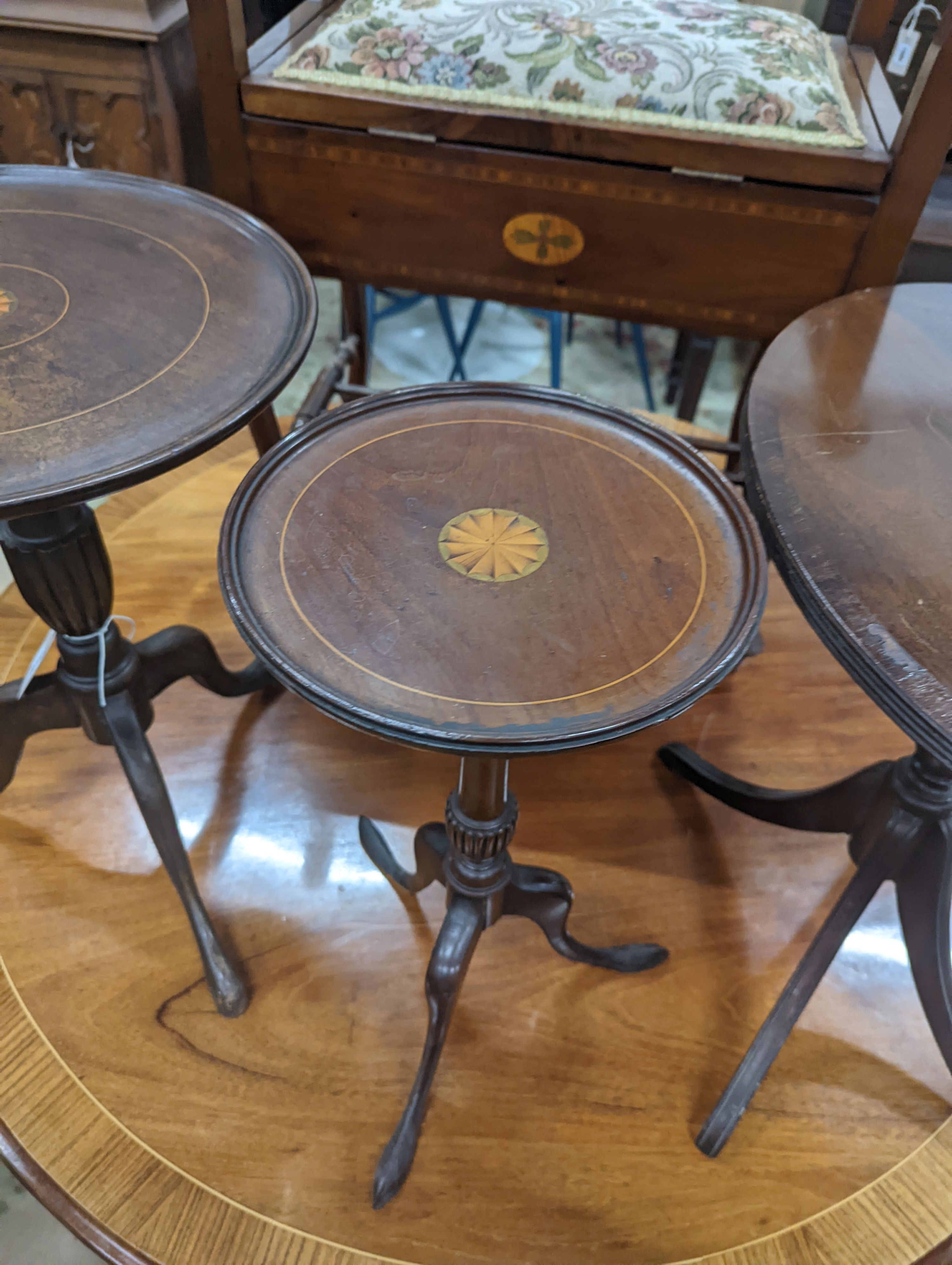 Two Edwardian inlaid mahogany tripod wine tables, larger height 50cm, together with a later folding oval wine table (3)